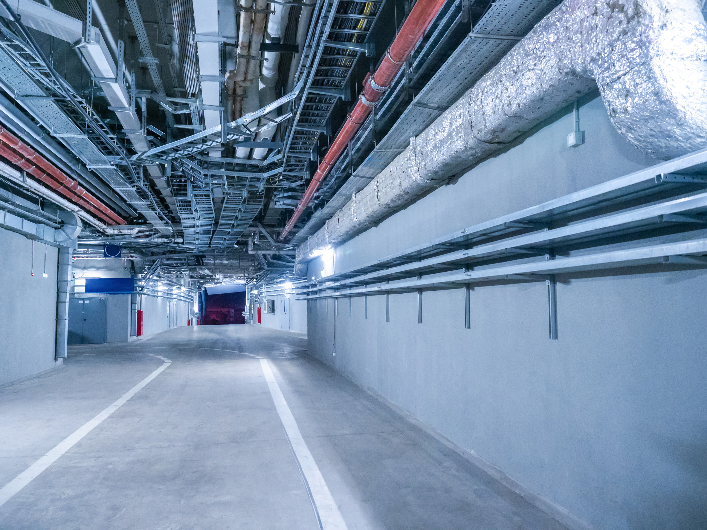 Engineering premises of stadium. Auxiliary corridors for passage of special equipment. Place for passage of special equipment inside stadium. Spacious corridors of stadium with pipes under ceiling